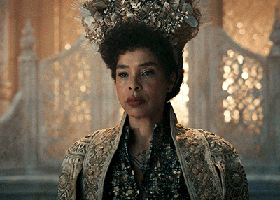 a woman with a crown on her head and a gold jacket