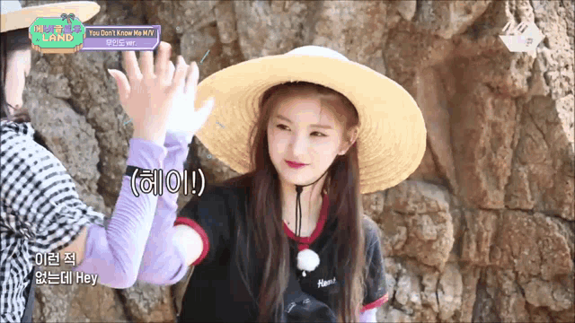 a girl wearing a hat and gloves is giving a high five to another girl .