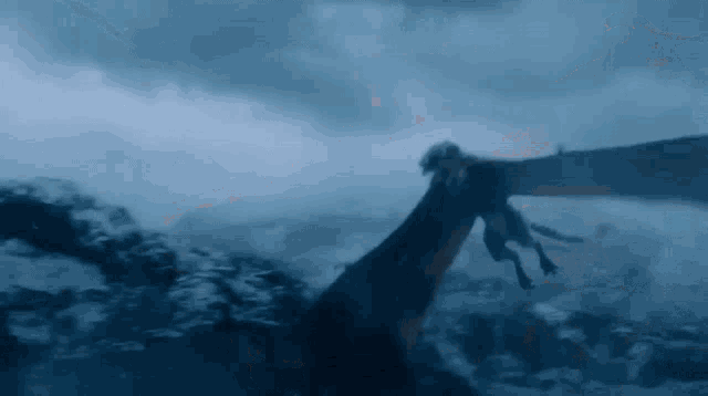 a dragon is flying through the air over a mountain range .