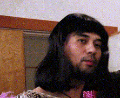 a man with long hair and a beard is wearing a pink tie