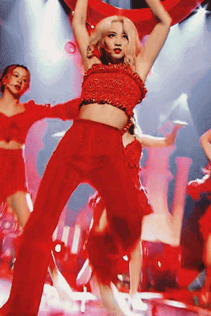 a woman in a red top and red pants is dancing
