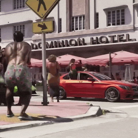 a red car is parked outside the dominion hotel
