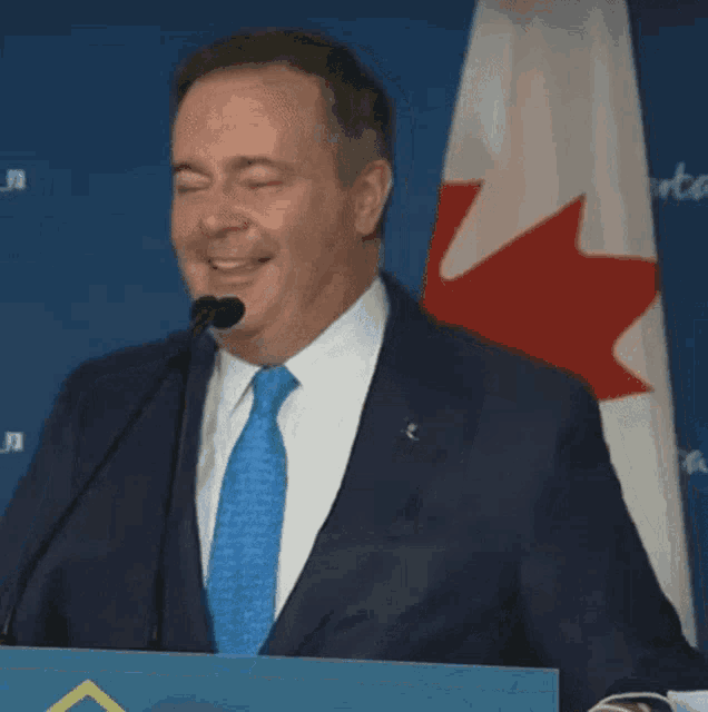 a man in a suit and tie is smiling at a microphone