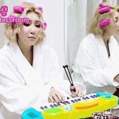 a woman with pink curlers on her head is playing a toy piano