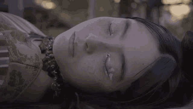 a woman is laying down with her eyes closed
