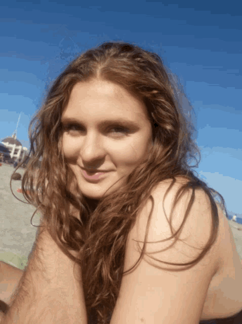 a woman with long hair smiles for the camera