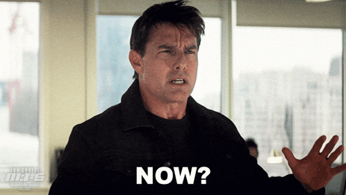 a man in a black jacket says " now " in front of a window