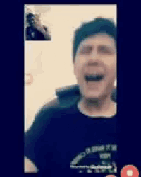 a man is laughing on a video call while wearing a black shirt .
