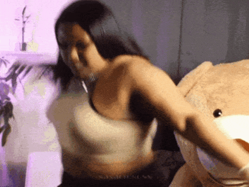 a woman is standing next to a large teddy bear