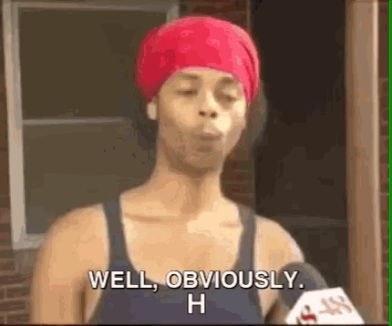 a woman wearing a red headband is talking into a microphone and saying `` well obviously , h '' .