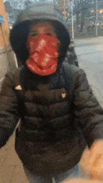 a person wearing a black jacket and a red bandana