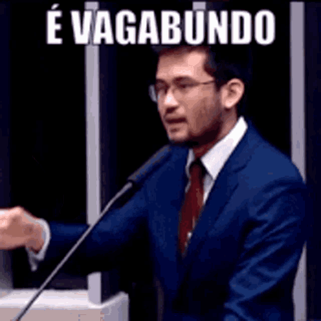 a man in a suit and tie is giving a speech in front of a microphone with the words e vagabundo above him