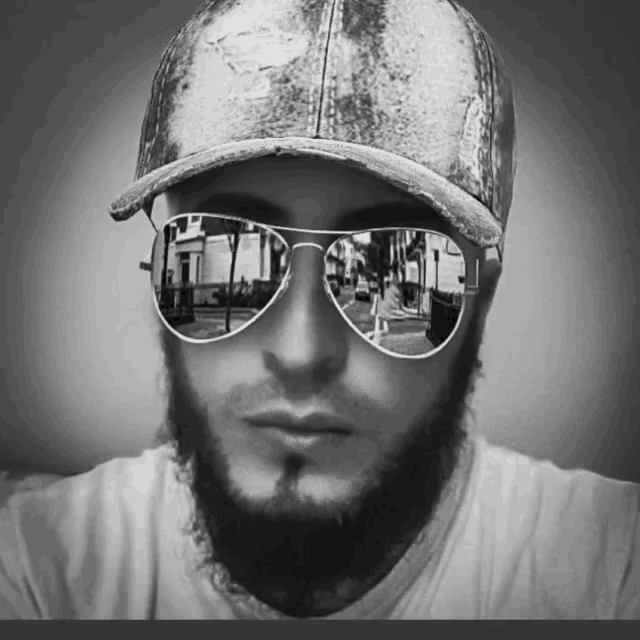 a man with a beard wearing sunglasses and a baseball hat