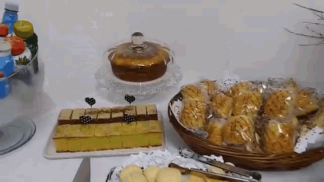 a table with a variety of food including a cake and a basket of cookies