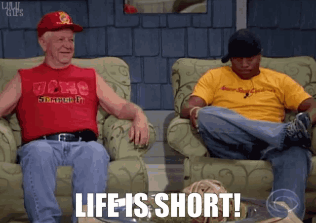 two men are sitting on a couch with the words life is short written below them