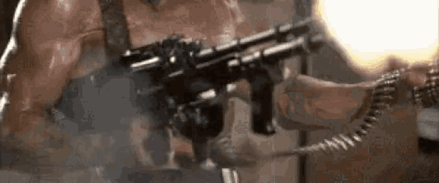 a man is holding a gun with smoke coming out of it in a room .
