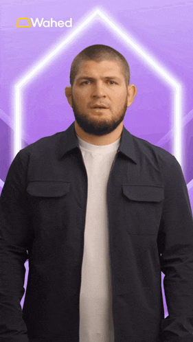 a man in a black jacket stands in front of a purple background with the word wahed on it