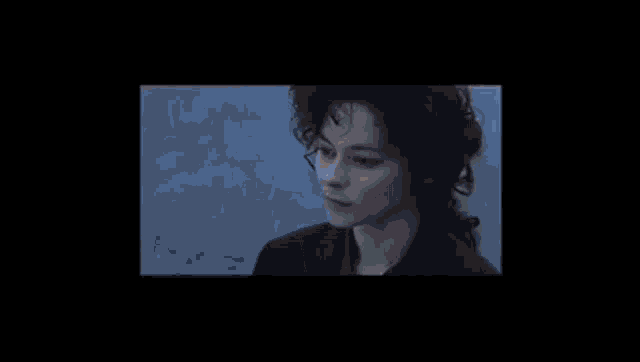a close up of a person 's face with a shadow on the wall behind them .