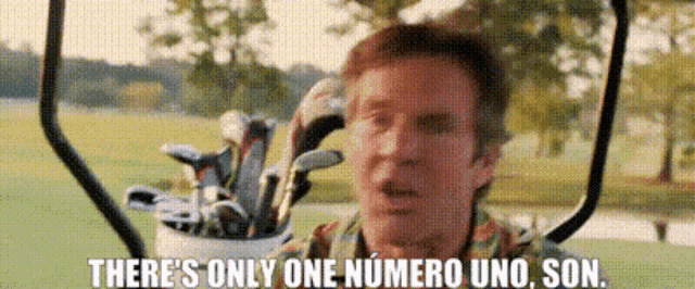 a man is sitting in a golf cart holding a bag of golf clubs and says there 's only one numero uno son