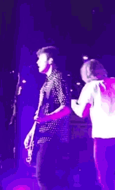 a man is playing a guitar on stage in front of a microphone .