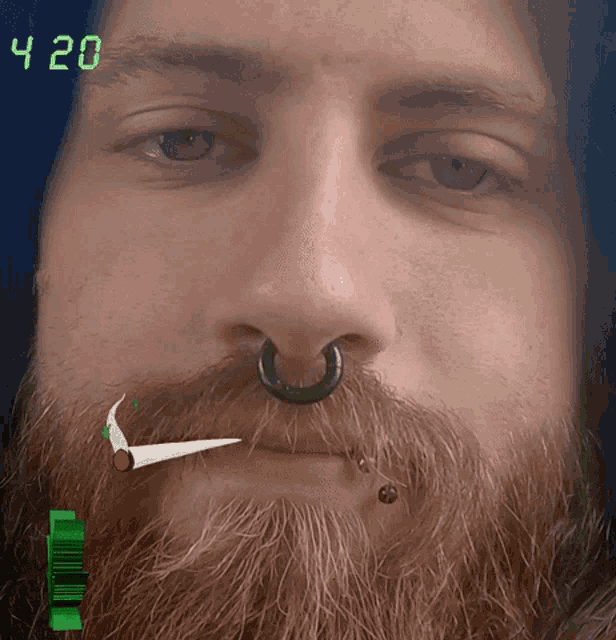 a man with a beard and a nose ring smoking a cigarette with the time 4:20