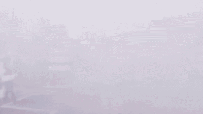 a football player is running on a field with smoke coming out of the stands .