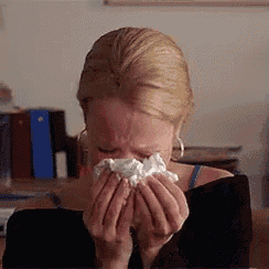 a woman is blowing her nose into a napkin while crying