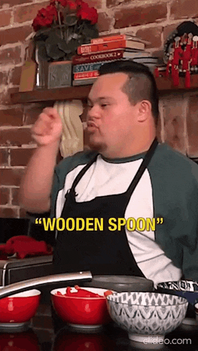 a man in an apron is holding a wooden spoon in his hand