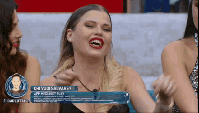 a woman laughs in front of a sign that says chi vuoi salvare app mediaset play
