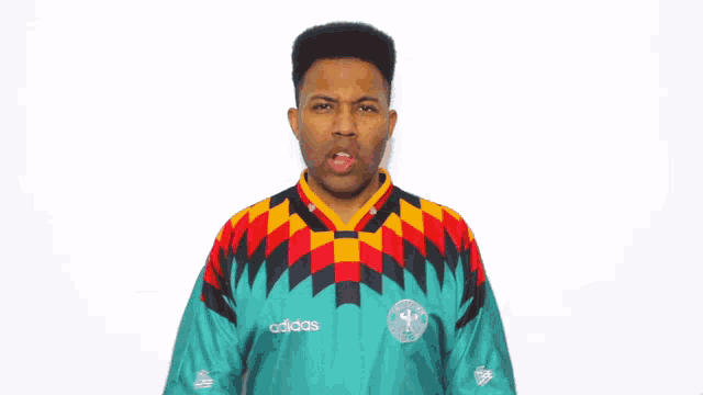 a man wearing a shirt that says ' adidas ' on it is making a funny face