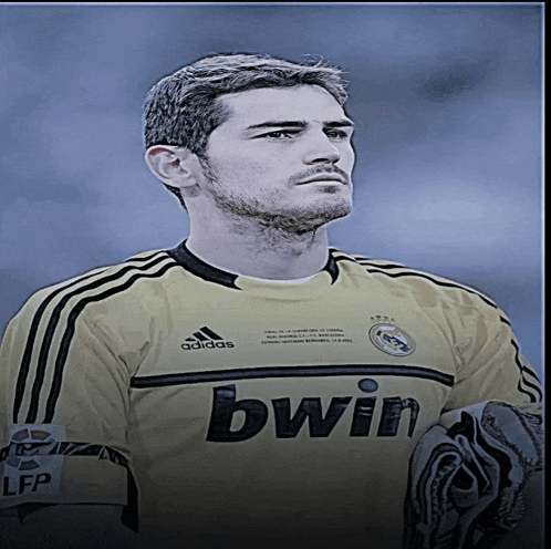 a man wearing a yellow adidas jersey with bwin written on it