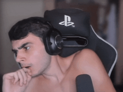 a shirtless man wearing headphones is sitting in a chair with a playstation logo on it