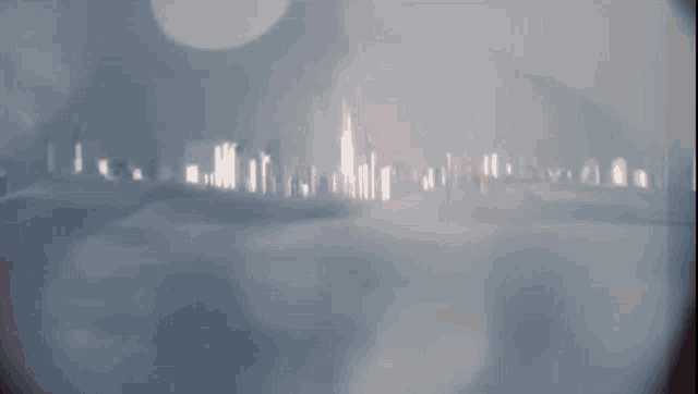 a blurry picture of a city skyline with a tower in the distance