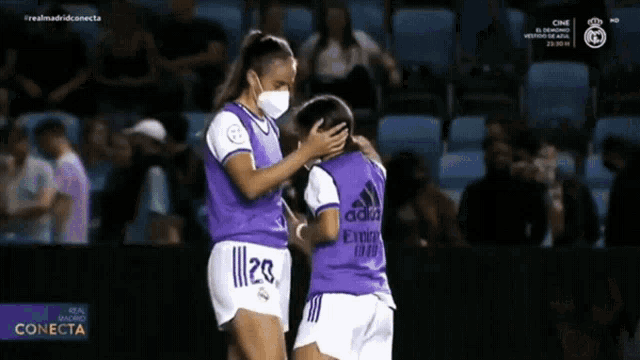 two female soccer players one wearing a purple jersey with the number 20