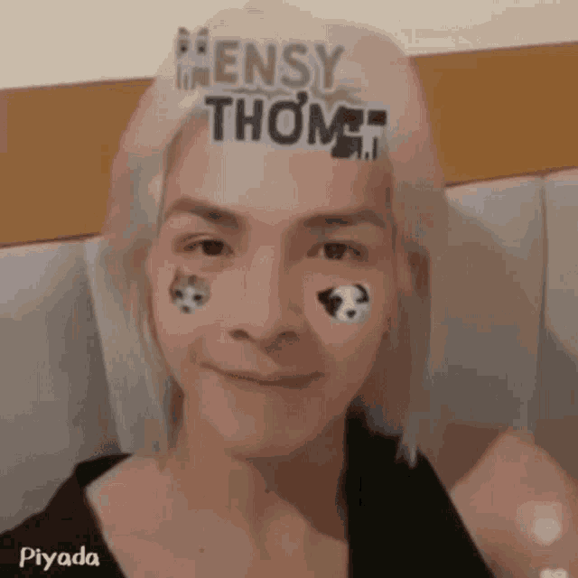 a man with a sticker on his forehead that says ' ensy thom ' on it .