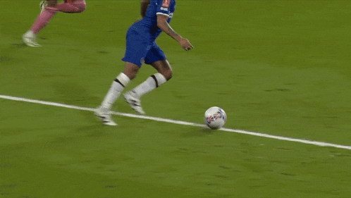 a soccer field with emirates fly better signs