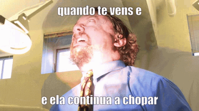 a man in a blue shirt and tie with the words quando te vens e e ela continua a chopar written below him