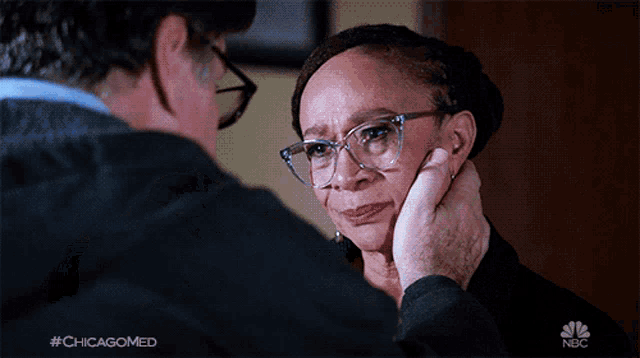 a man touching a woman 's face with the hashtag #chicagomed on the bottom