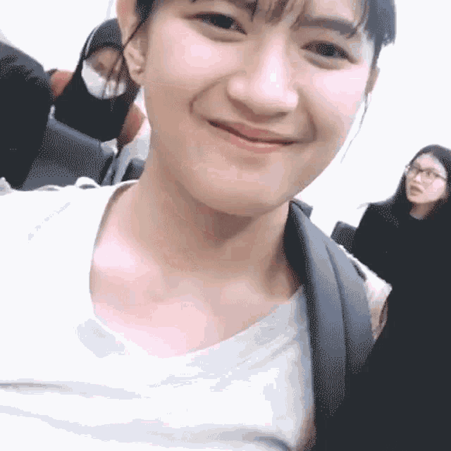 a girl with glasses and a backpack smiles at the camera