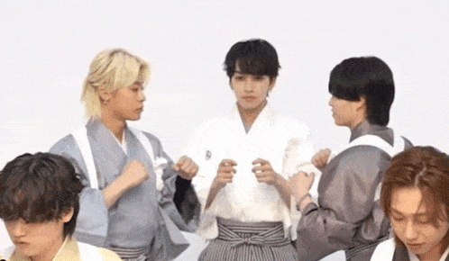 a group of young men standing next to each other in kimonos