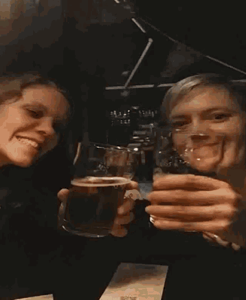 a man and a woman are toasting with a glass of beer that has the word guinness on it