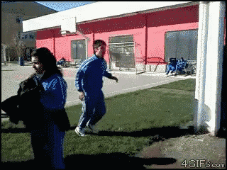 a man and a woman are walking in front of a red building and the website 4gifs.com is visible in the corner