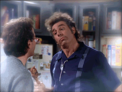 a man in a blue shirt is talking to another man in front of a fridge with cereal on it