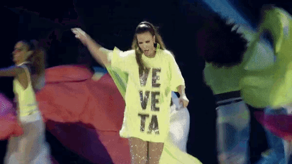a woman wearing a neon yellow shirt that says ve ve ta