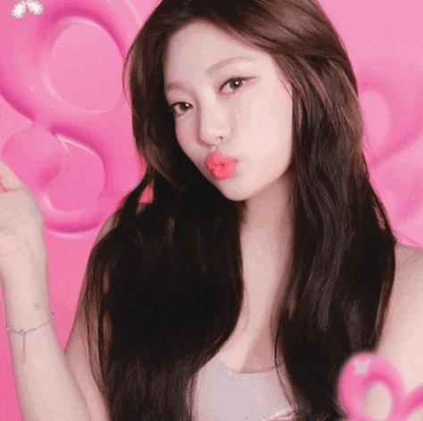 a woman blowing a kiss in front of a pink heart