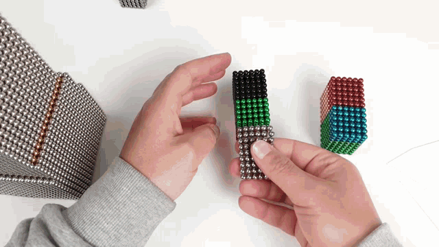 a person is playing with a stack of magnetic balls