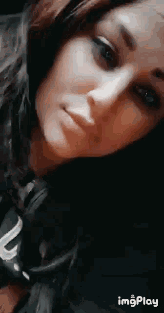 a close up of a woman 's face with headphones on looking at the camera .