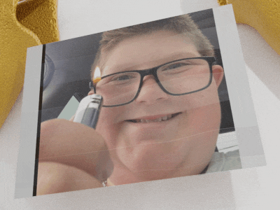 a boy wearing glasses is holding a lighter