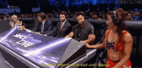 a man and a woman are sitting in front of a sign that says smackdown live