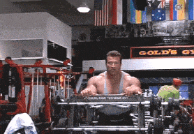 a man in a gym with a sign that says gold 's gym on it